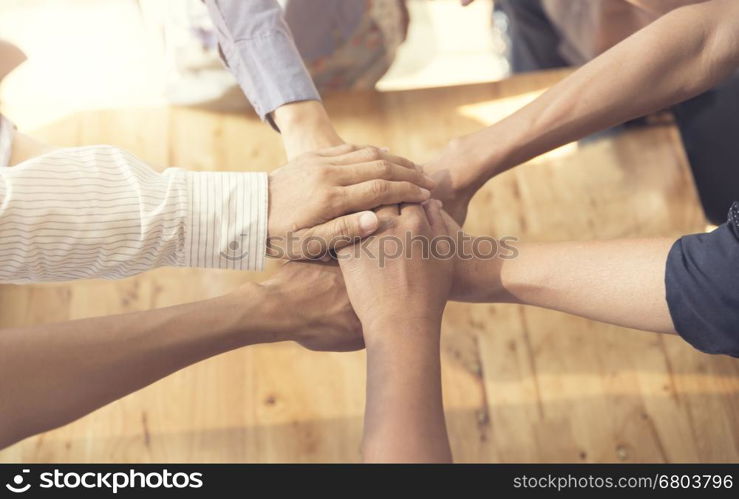 people putting their hands together for united, cooperation and teamwork concept, selective focus and vintage tone