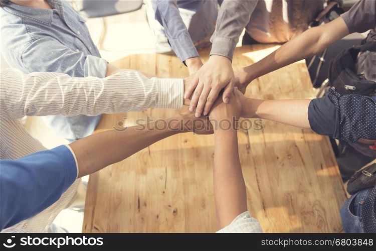 people putting their hands together for united, cooperation and teamwork concept, selective focus and vintage tone