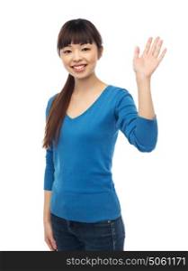 people, race, ethnicity and gesture concept - happy smiling young asian woman waving hand over white. happy smiling young woman waving hand over white
