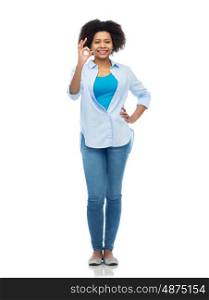 people, race, ethnicity and portrait concept - happy african american young woman showing ok hand sign over white