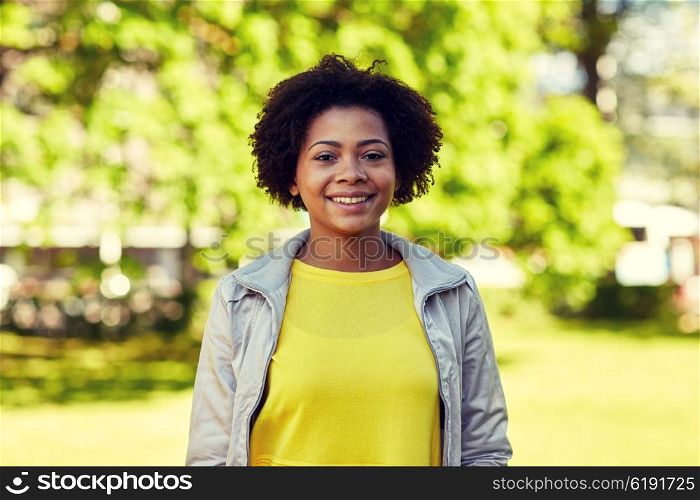 people, race, ethnicity and portrait concept - happy african american young woman in summer park