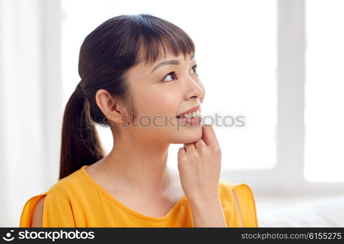 people, race, ethnicity and portrait concept - happy asian young dreaming woman or teenage girl face at home