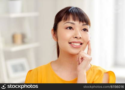 people, race, ethnicity and portrait concept - happy asian young dreaming woman or teenage girl face at home