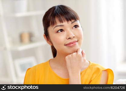 people, race, ethnicity and portrait concept - happy asian young dreaming woman or teenage girl face at home