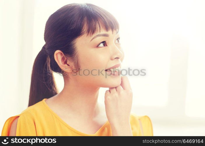 people, race, ethnicity and portrait concept - happy asian young dreaming woman or teenage girl face at home. happy asian young dreaming woman face at home