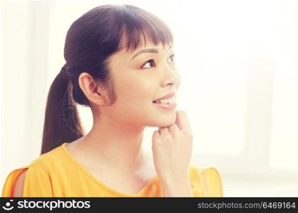 people, race, ethnicity and portrait concept - happy asian young dreaming woman or teenage girl face at home. happy asian young dreaming woman face at home