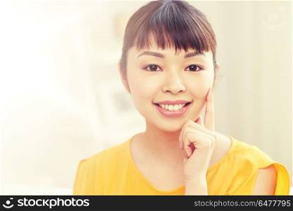 people, race, ethnicity and portrait concept - happy asian young woman or teenage girl face at home. happy asian young woman at home. happy asian young woman at home