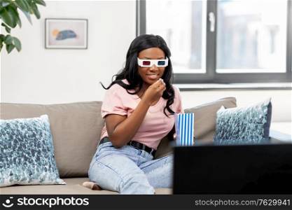 people, race, ethnicity and portrait concept - happy smiling african american young woman in 3d glasses watching tv and eating popcorn at home. happy african american woman watching tv at home