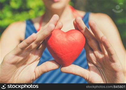 people, relationship and love concept - womans hands holding red heart on blue background. Relationship and love concept - womans hands holding red heart