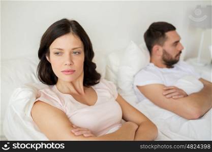 people, relationship difficulties and family concept - unhappy couple having conflict in bed at home