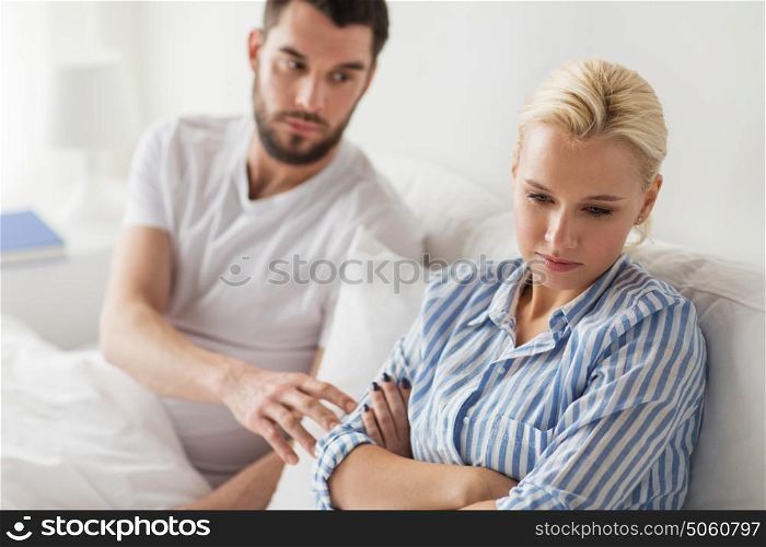 people, relationship difficulties and family concept - unhappy couple having conflict in bed at home. unhappy couple having conflict in bed at home