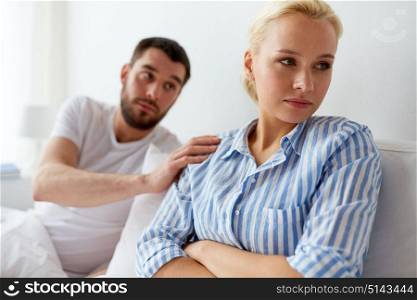 people, relationship difficulties and family concept - unhappy couple having conflict in bed at home. unhappy couple having conflict in bed at home