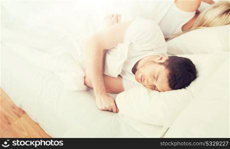 people, relationship difficulties, conflict and family concept - couple sleeping back to back in bed at home. couple sleeping in bed at home
