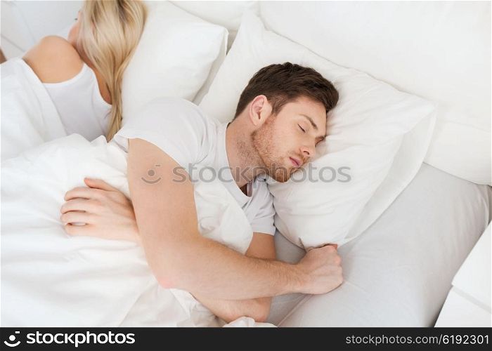 people, relationship difficulties, conflict and family concept - couple sleeping back to back in bed at home