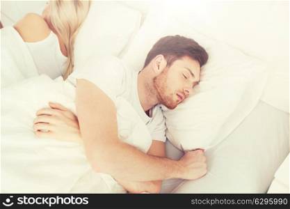people, relationship difficulties, conflict and family concept - couple sleeping back to back in bed at home. couple sleeping in bed at home