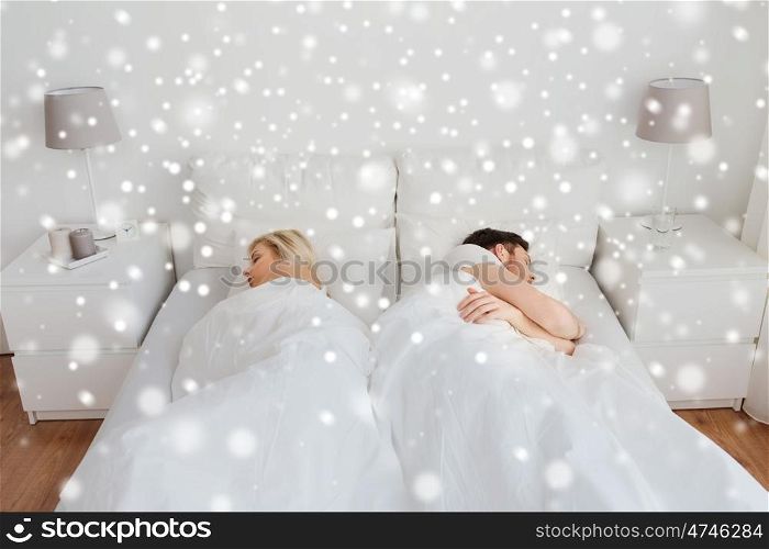 people, relationship difficulties, conflict and family concept - couple sleeping in bed at home over snow