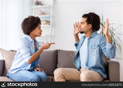 people, relationship difficulties, conflict and family concept - unhappy couple having argument and blaming each other at home. unhappy couple having argument at home