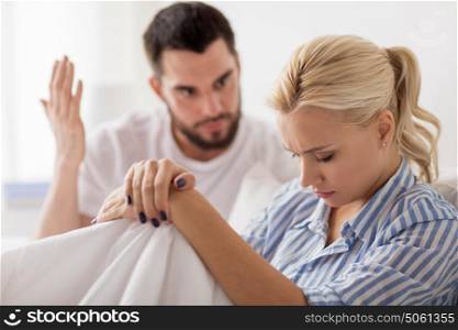 people, relationship difficulties, conflict and family concept - unhappy couple having quarrel in bed at home. unhappy couple having conflict in bed at home