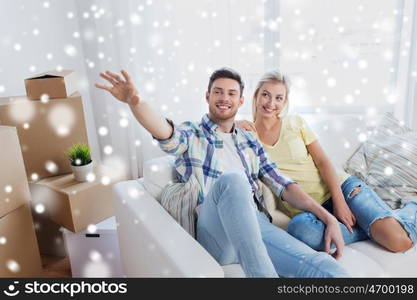 people, repair and real estate concept - smiling couple with boxes moving to new home and dreaming about future over snow