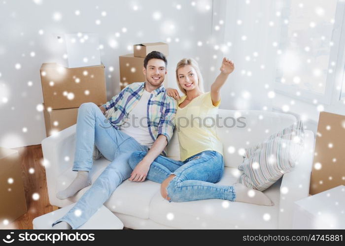 people, repair and real estate concept - smiling couple with boxes moving to new home and dreaming over snow