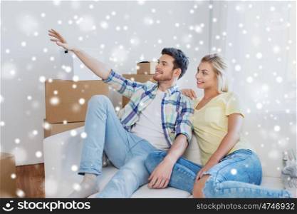 people, repair and real estate concept - smiling couple with boxes moving to new home and dreaming over snow