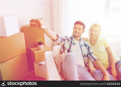 people, repair and real estate concept - smiling couple with boxes moving to new home and dreaming