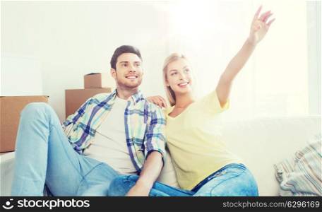 people, repair and real estate concept - smiling couple with boxes moving to new home and dreaming. couple with boxes moving to new home and dreaming