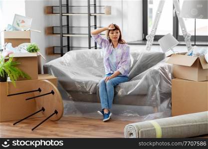people, repair and real estate concept - tired asian woman with stuff moving to new home. tired asian woman with stuff moving to new home