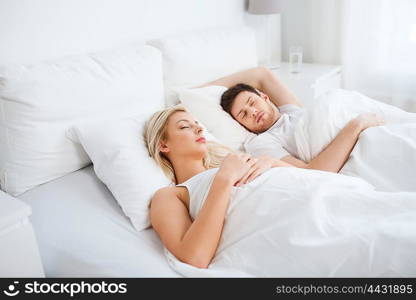 people, rest and relationships concept - happy couple sleeping in bed at home