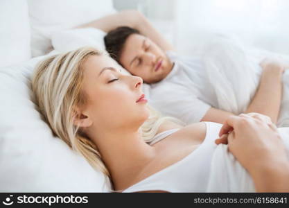 people, rest and relationships concept - happy couple sleeping in bed at home