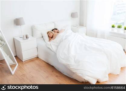 people, rest and relationships concept - happy couple sleeping in bed at home