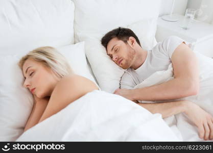 people, rest and relationships concept - happy couple sleeping in bed at home