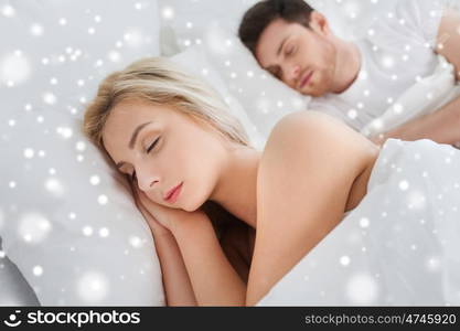 people, rest and relationships concept - happy couple sleeping in bed at home over snow