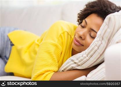 people, rest, comfort and leisure concept - african american young woman sleeping on sofa at home