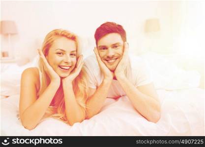 people, rest, love, relationships and happiness concept - happy couple lying in bed at home. happy couple lying in bed at home