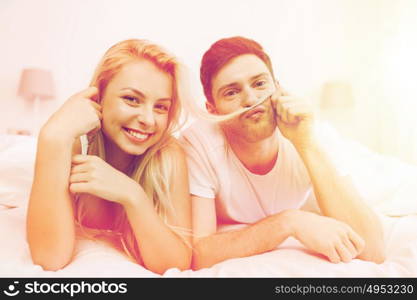 people, rest, love, relationships and happiness concept - happy couple lying in bed at home. happy couple lying in bed at home