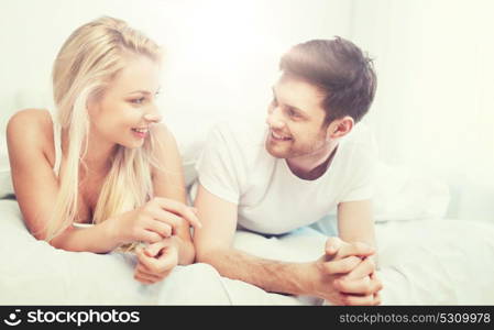 people, rest, love, relationships and happiness concept - happy couple lying in bed at home. happy couple lying in bed at home