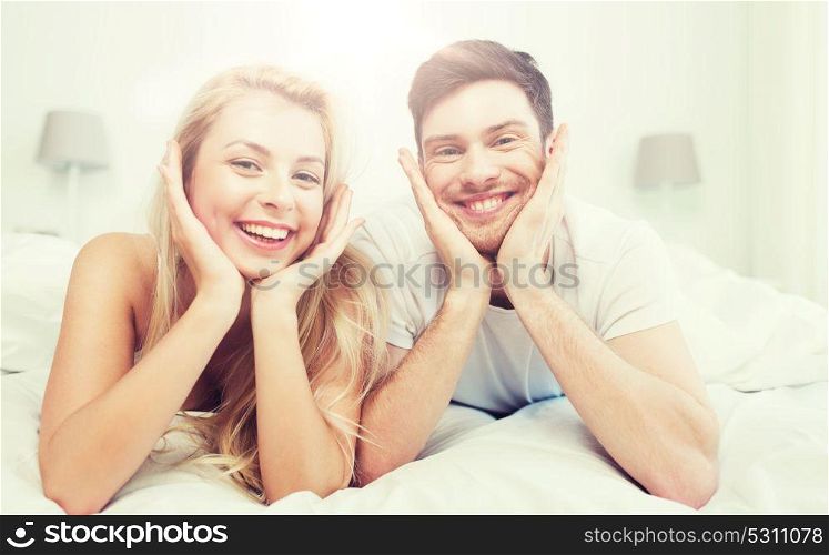 people, rest, love, relationships and happiness concept - happy couple lying in bed at home. happy couple lying in bed at home