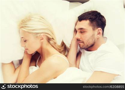 people, rest, relationships and happiness concept - happy couple of man and woman sleeping in bed