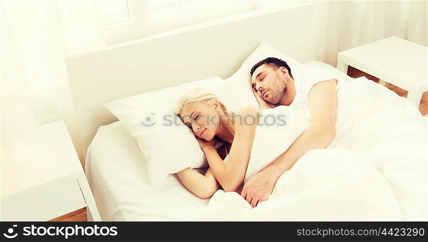 people, rest, relationships and happiness concept - happy couple sleeping in bed at home