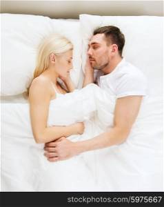 people, rest, relationships and happiness concept - happy couple sleeping in bed at home