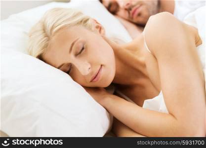people, rest, relationships and happiness concept - happy woman and man sleeping in bed at home