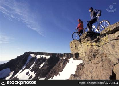 People Resting on Mountain Bikes Together