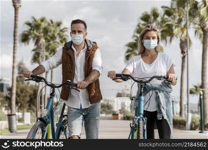 people riding bike while wearing medical mask