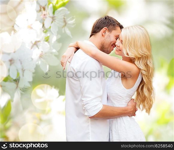 people, romance, love and dating concept - happy couple hugging over green blooming summer garden background