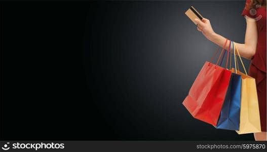 people, sale, black friday and consumerism concept - close up of woman with shopping bags and bank or credit card