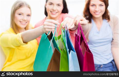 people, sale, consumerism and lifestyle concept - close up of happy teenage girls or young women with shopping bags