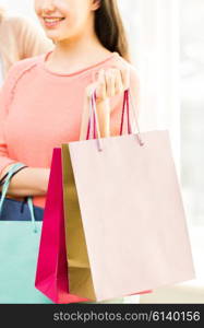 people, sale, consumerism and lifestyle concept - close up of happy teenage girls or young women with shopping bags