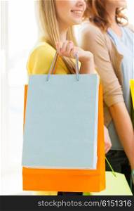 people, sale, consumerism and lifestyle concept - close up of happy teenage girls or young women with shopping bags