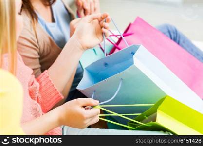 people, sale, consumerism and lifestyle concept - close up of teenage girls or young women with shopping bags
